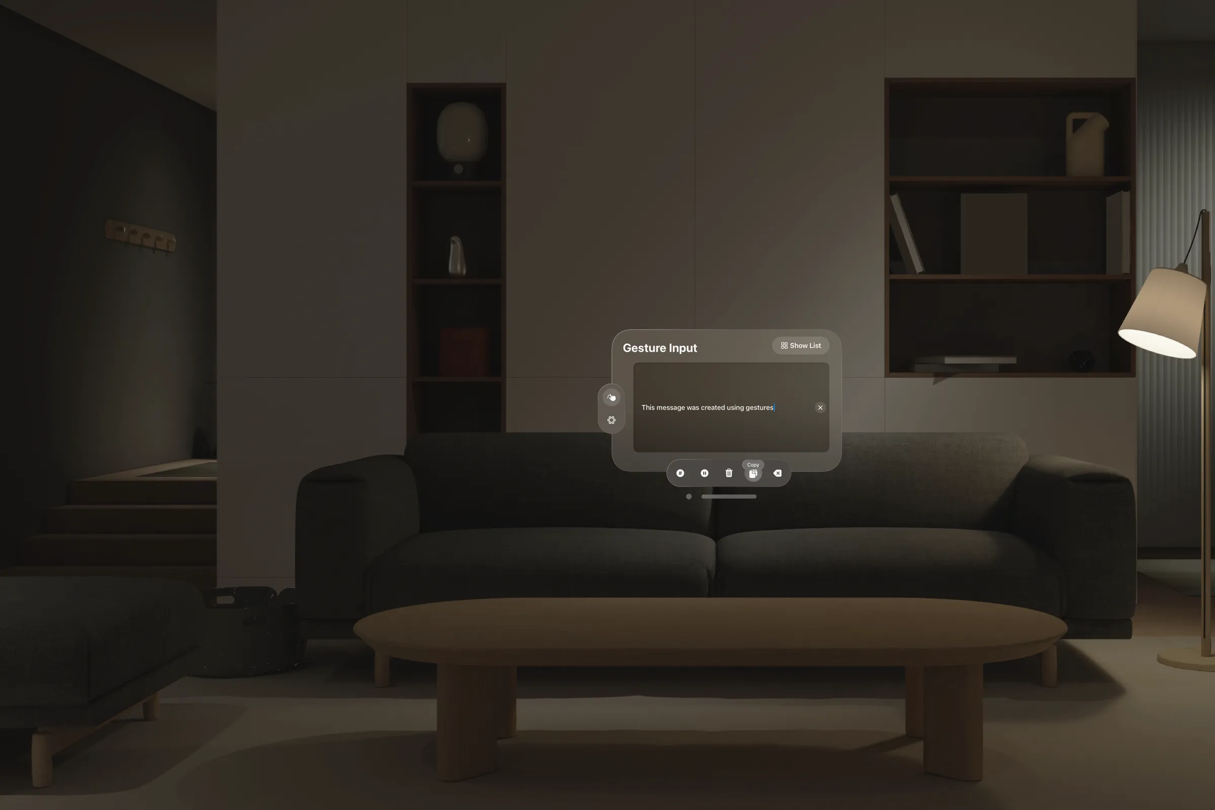 The Gesture Input window floating in a dim living room in visionOS: a text field reading “This message was created using gestures,” with copy, clear, and backspace controls beneath it.
