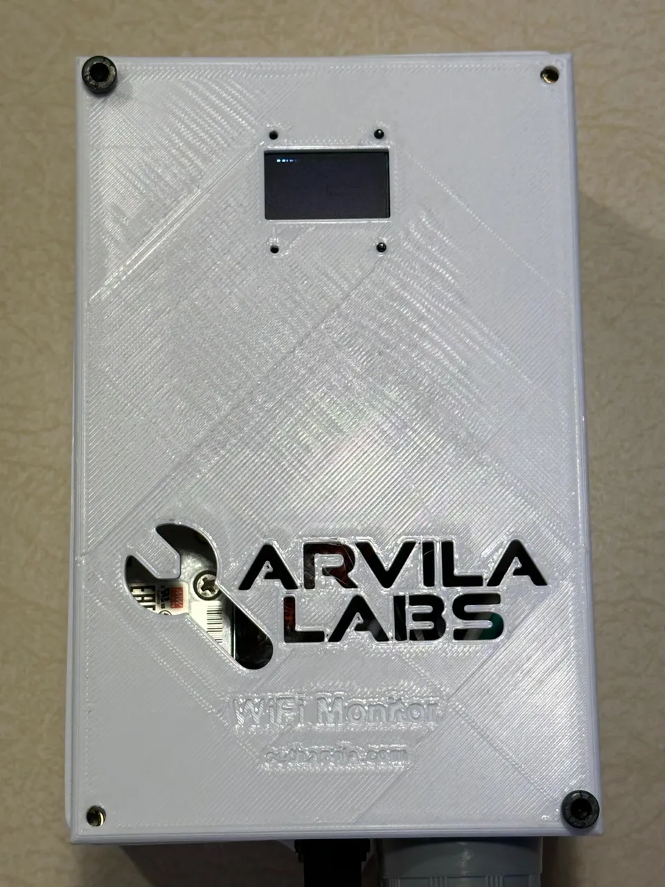 The WiFi Monitor, a white 3D-printed enclosure with a small display and an Arvila Labs logo.